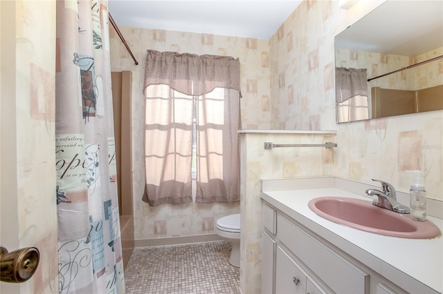 bathroom featuring vanity, baseboards, wallpapered walls, tile patterned flooring, and toilet