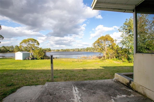 view of yard with a water view, an outdoor structure, and a shed