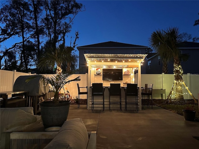 view of patio featuring a fenced backyard, a pergola, and outdoor dry bar