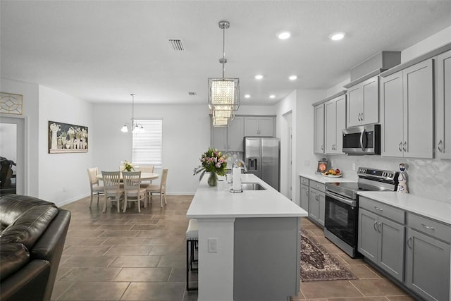 kitchen with visible vents, light countertops, decorative backsplash, gray cabinets, and stainless steel appliances