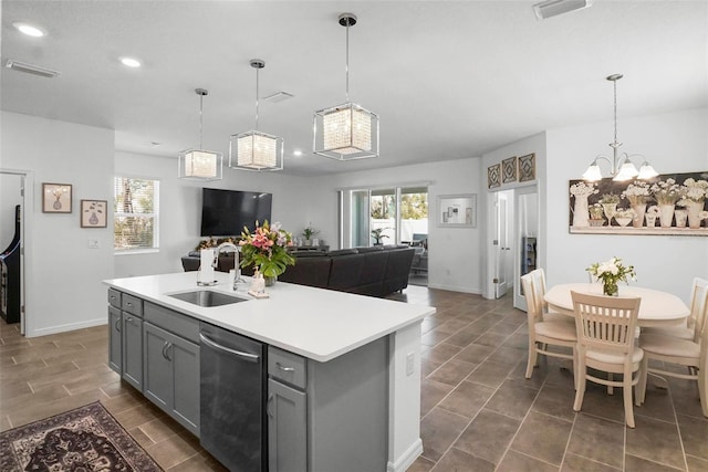 kitchen featuring gray cabinets, a sink, light countertops, dishwasher, and open floor plan