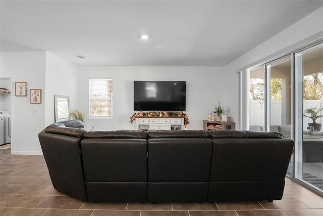 living room with washer and dryer and tile patterned flooring