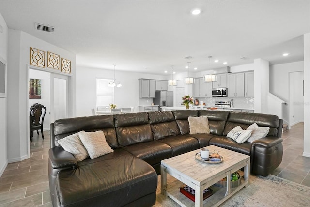 living area featuring visible vents, a notable chandelier, recessed lighting, light tile patterned floors, and baseboards