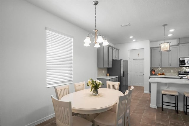 dining room with baseboards, visible vents, dark tile patterned flooring, recessed lighting, and a notable chandelier