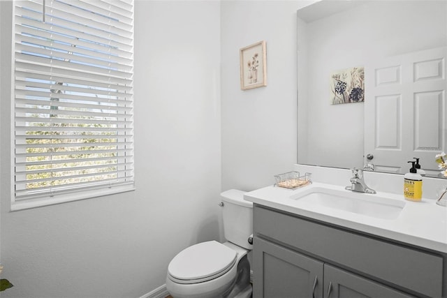 bathroom with vanity, toilet, and baseboards