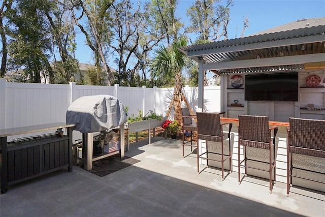 view of patio / terrace featuring outdoor dry bar, grilling area, and a fenced backyard