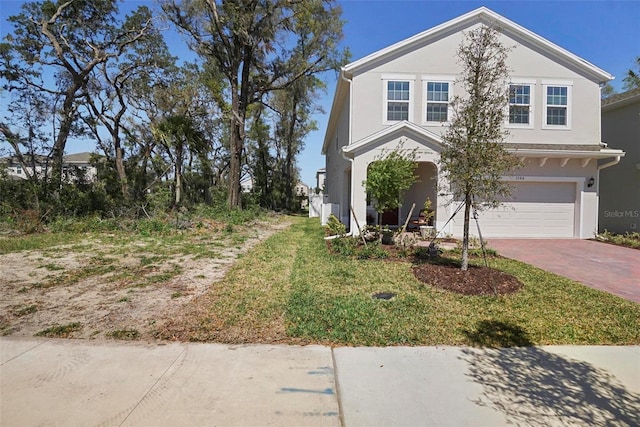 traditional home featuring decorative driveway, a garage, and stucco siding