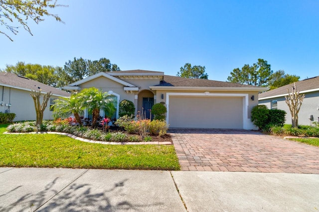 view of front of house with decorative driveway, a garage, a front lawn, and stucco siding