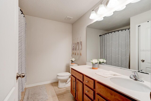 full bath with tile patterned floors, visible vents, toilet, baseboards, and vanity