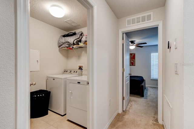 laundry room featuring laundry area, washing machine and dryer, a textured ceiling, and visible vents