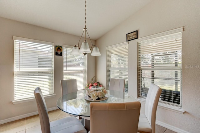 tiled dining room with baseboards and lofted ceiling