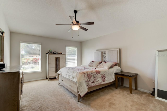 bedroom featuring light carpet, multiple windows, baseboards, and ceiling fan