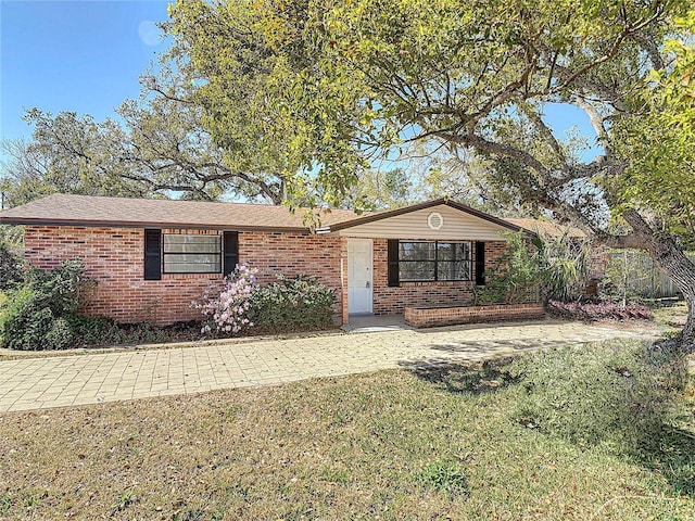 ranch-style home with brick siding and a front yard