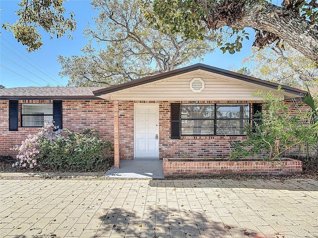 single story home featuring brick siding