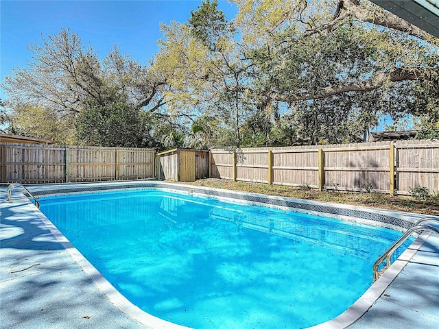 view of pool with a storage unit, a fenced in pool, an outdoor structure, and a fenced backyard