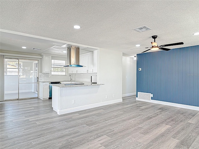 kitchen featuring ventilation hood, a ceiling fan, visible vents, white cabinets, and light wood-style floors