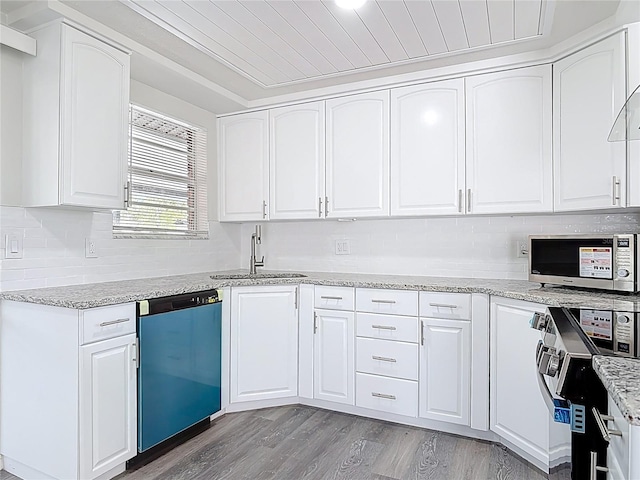 kitchen featuring stainless steel microwave, light stone countertops, dishwasher, light wood-type flooring, and a sink