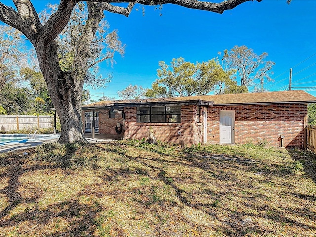 back of property featuring brick siding and fence