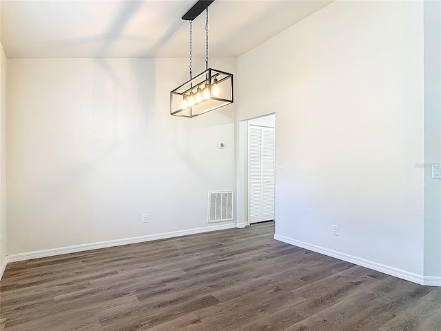 spare room featuring baseboards, visible vents, dark wood-style flooring, and high vaulted ceiling