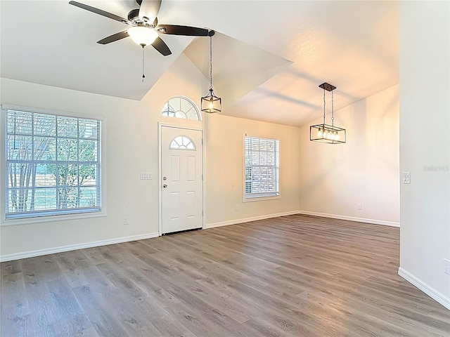 foyer entrance featuring a ceiling fan, lofted ceiling, wood finished floors, and baseboards