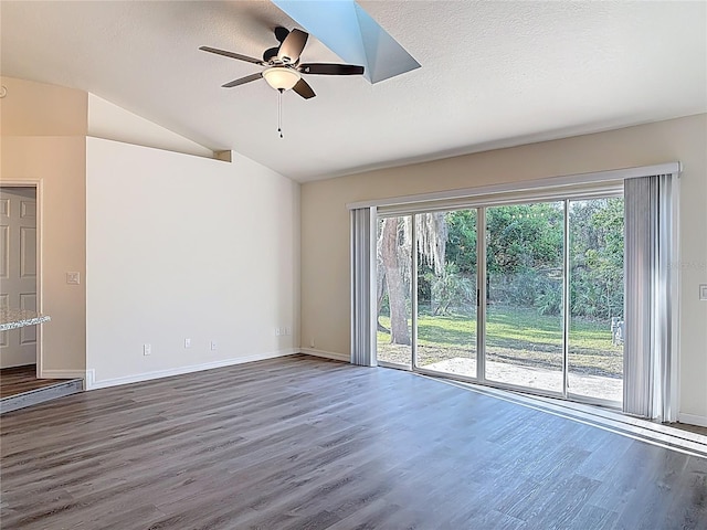 unfurnished room featuring a textured ceiling, ceiling fan, dark wood-style flooring, and vaulted ceiling