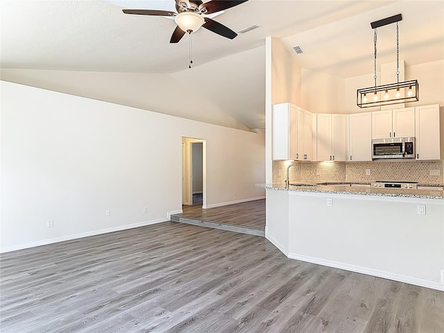 kitchen featuring open floor plan, stainless steel microwave, ceiling fan, and visible vents