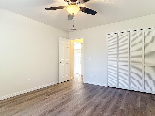 unfurnished bedroom with visible vents, dark wood-type flooring, baseboards, a closet, and a ceiling fan