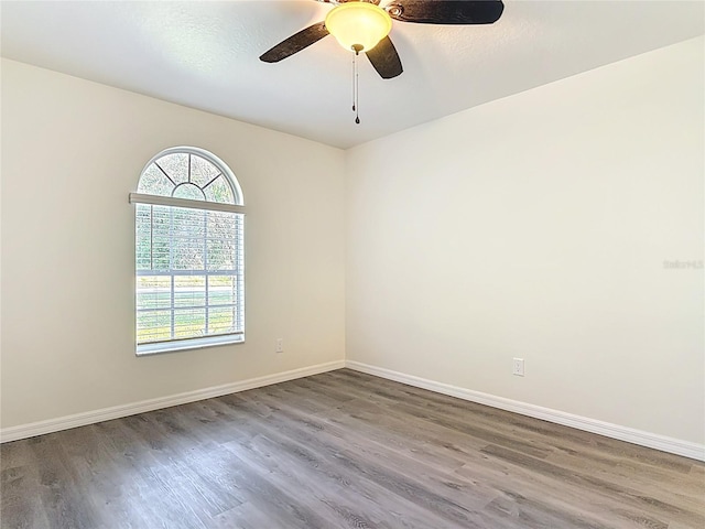 spare room with wood finished floors, baseboards, and ceiling fan