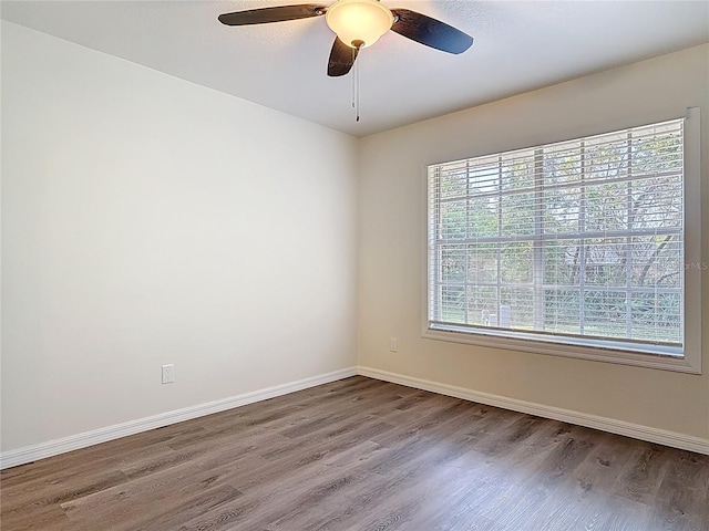 spare room with wood finished floors, baseboards, and ceiling fan