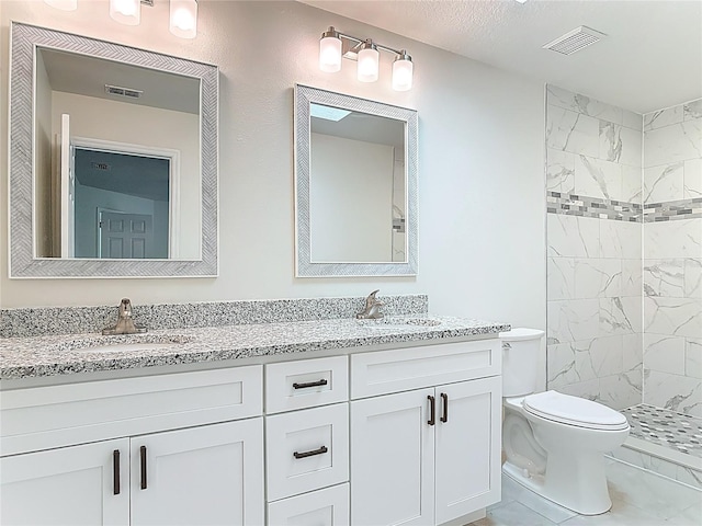 bathroom featuring a sink, visible vents, toilet, and double vanity