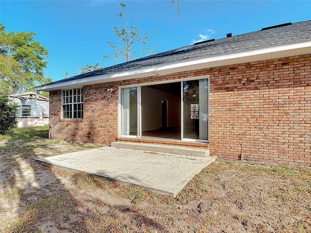 back of property with brick siding and a patio area