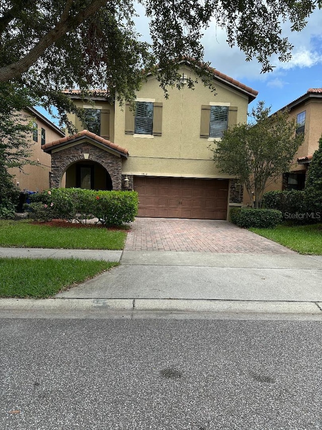 1812 Leather Fern Dr, Ocoee, FL 34761 - view of front of property with decorative driveway, a garage, stucco siding, and stone siding