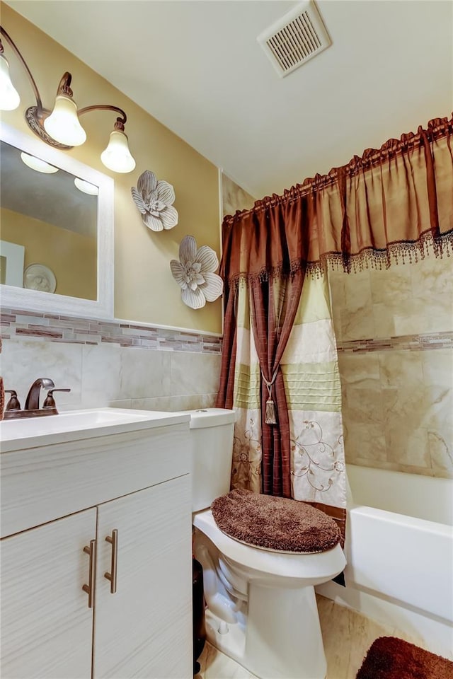 bathroom with visible vents, toilet, shower / bath combo, tile walls, and vanity