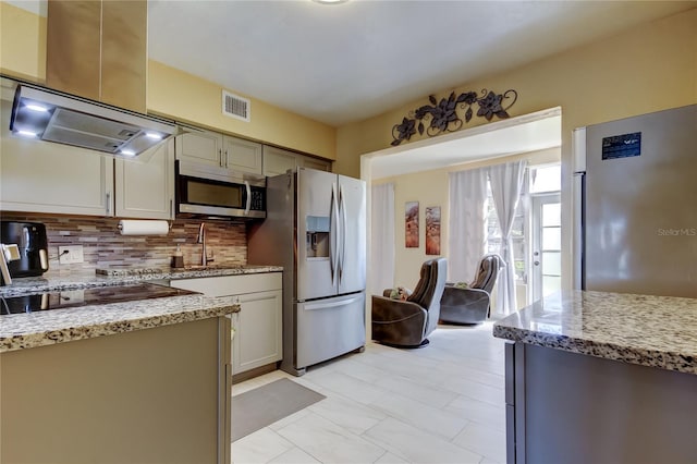 kitchen with visible vents, light stone counters, tasteful backsplash, appliances with stainless steel finishes, and island range hood