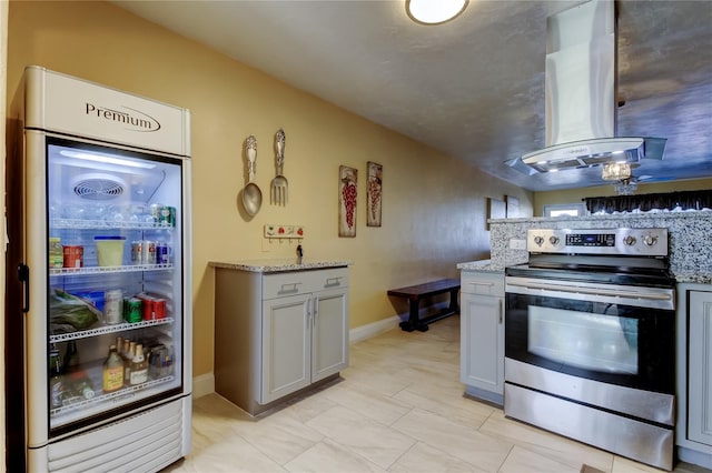 kitchen with stainless steel electric range oven, light stone countertops, range hood, and refrigerator with glass door