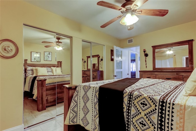 bedroom with visible vents, ceiling fan, and multiple closets