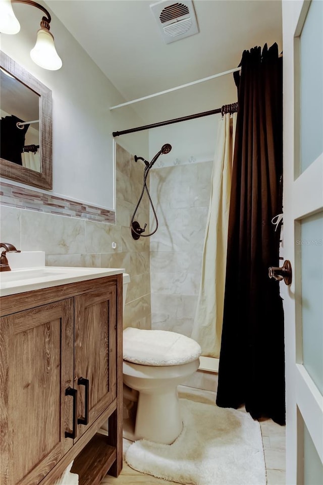 full bath featuring vanity, a shower with curtain, visible vents, tile walls, and toilet