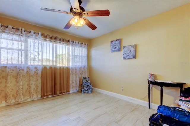 interior space with baseboards and ceiling fan