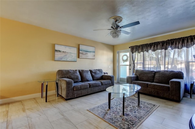 living room featuring baseboards and ceiling fan