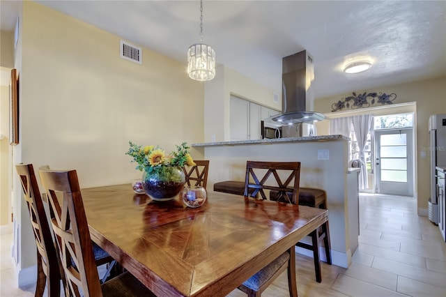 dining area with light tile patterned floors and visible vents