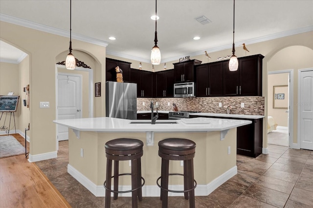 kitchen featuring arched walkways, visible vents, appliances with stainless steel finishes, and a sink