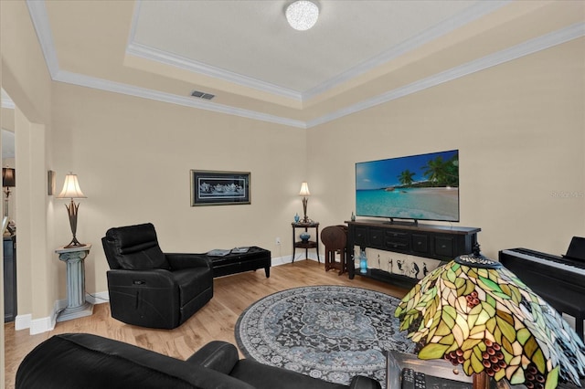 living room featuring crown molding, wood finished floors, visible vents, and a raised ceiling