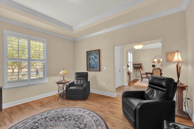 living area with light wood-style flooring, plenty of natural light, and ornamental molding