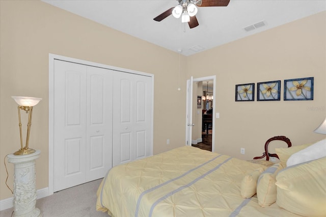 carpeted bedroom with a closet, visible vents, and ceiling fan