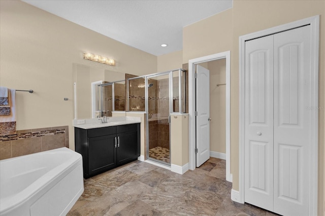 bathroom with a closet, vanity, a shower stall, and a garden tub