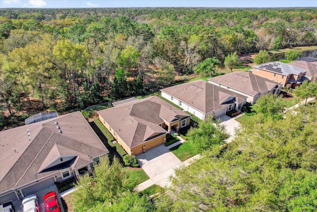 drone / aerial view featuring a forest view and a residential view