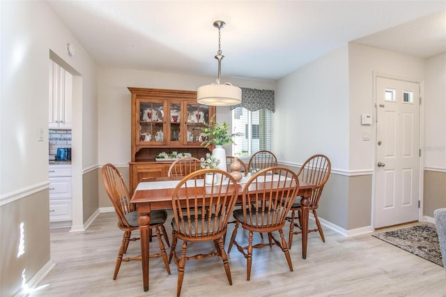 dining room featuring light wood-type flooring and baseboards