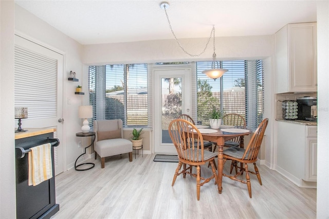 dining area featuring baseboards and light wood finished floors