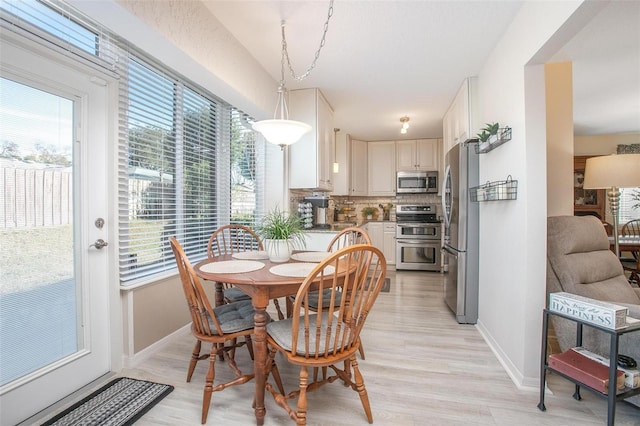 dining room with baseboards and light wood-style floors