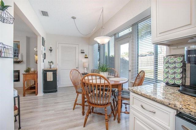 dining area with visible vents and light wood-type flooring